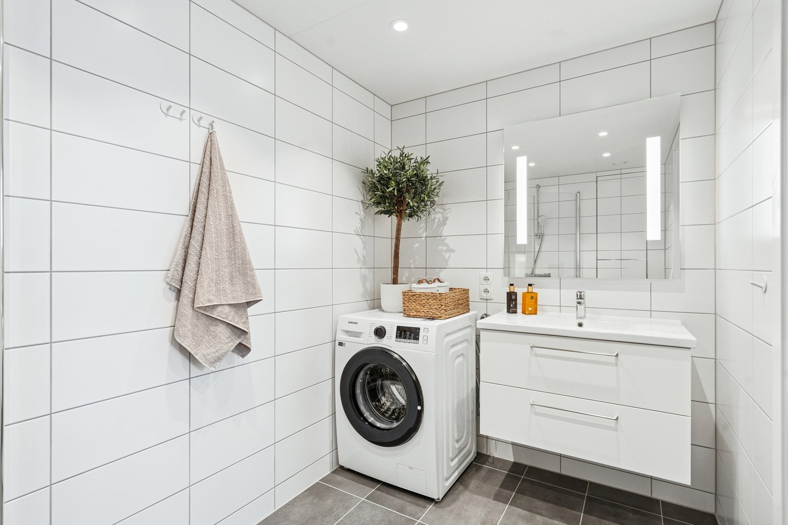 Innredningen er også lik på begge bad, og består er stilren og moderne, med hvite, slette fronter og detaljer i stål. Gjestebadet har opplegg for vaskemaskin. Galleribilde