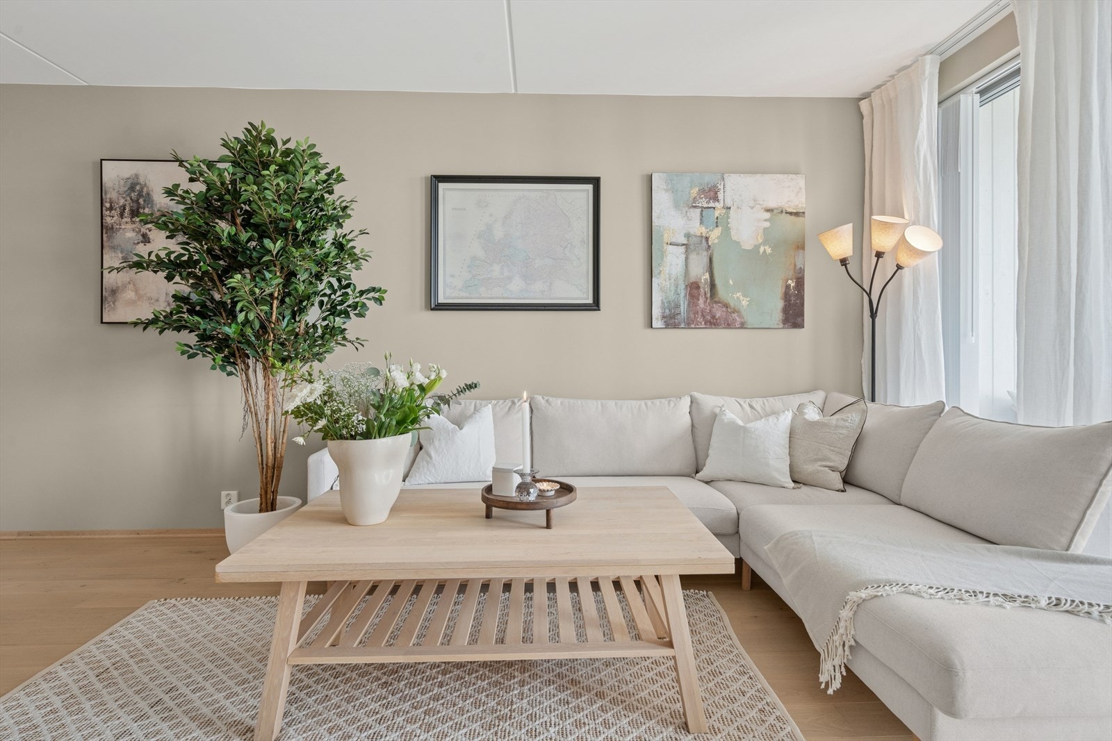 Stuedelen av rommet er i dag innredet med sofa og TV-benk. De store vinduene går fra gulv til tak og gir godt med naturlig lys. Galleribilde