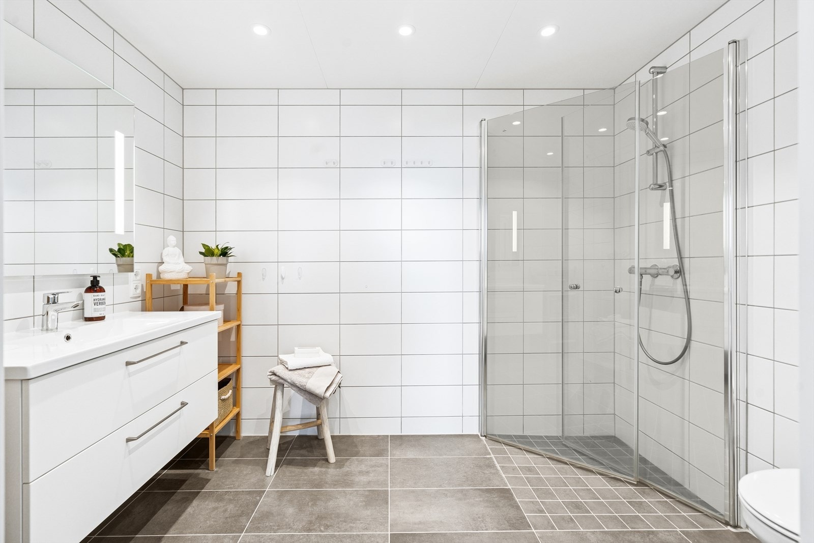 Badet er videre utstyrt med vegghengt toalett og dusjhjørne med innfallsdusjer i herdet glass. Galleribilde