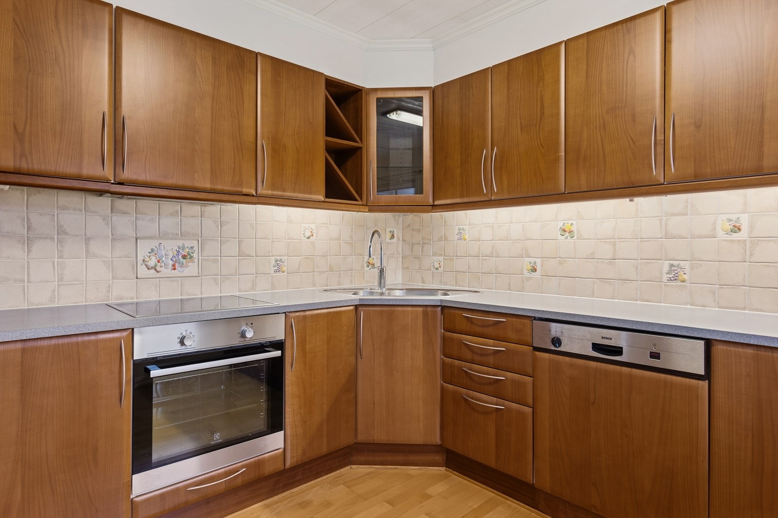 Det er lagt fliser på vegg over benkeplaten, samt belysning under overskapene. Galleribilde