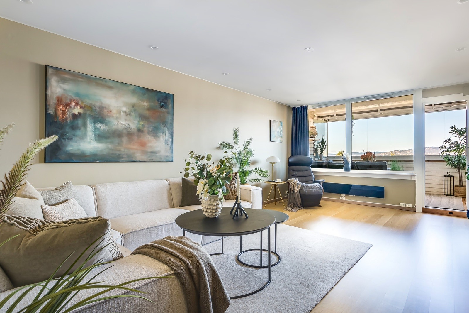 Luftig og elegant stue med harmonisk atmosfære og god plass til møblering. Lekre downlights i tak og ledstripe som omkranser taket fra merket Philips hue Galleribilde