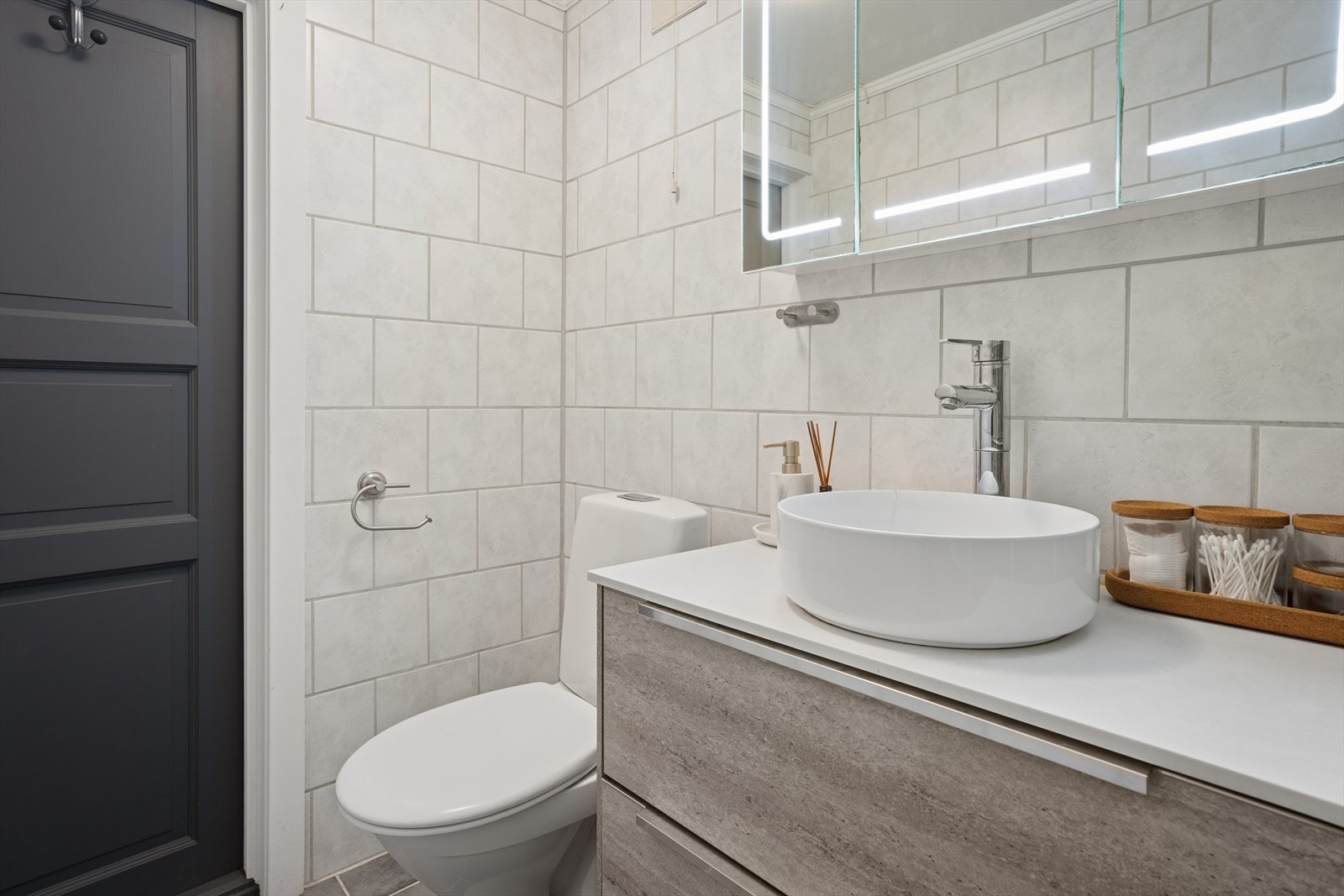 Badet er utstyrt med baderomsinnredning med servant og ett-greps blandebatteri. Toalett og speil overskap med led belysning. Rommet har elektrisk baderomsvifte. Galleribilde