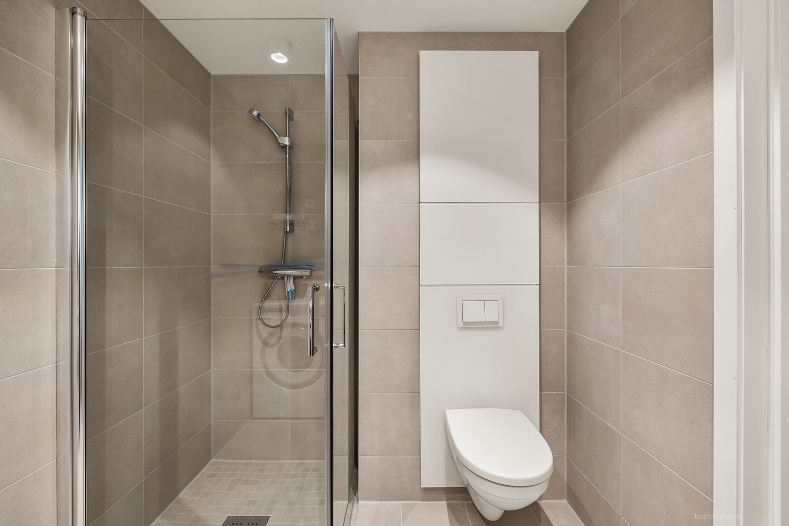 Videre har badet dusjhjørne med innfellbare dusjvegger og vegghengt toalett. Rommet har opplegg for vaskemaskin. Galleribilde