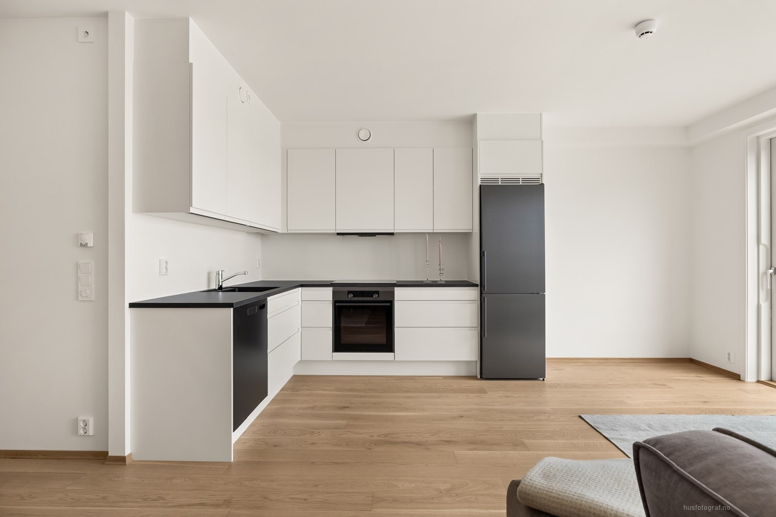 Lekkert og stilrent kjøkken med lyse slette overflater og et stilfullt design. Galleribilde