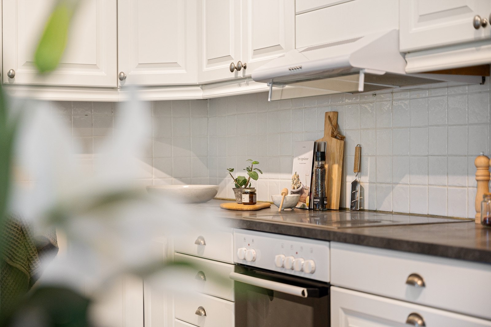 Integrert stekeovn og keramisk platetopp. Fliser mellom over- og underskapene. Galleribilde