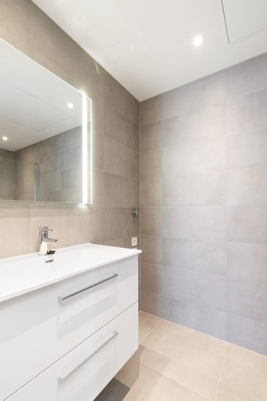 Bad med servant, vegghengt wc, dusjhjørne og opplegg for vaskemaskin og tørketrommel Galleribilde