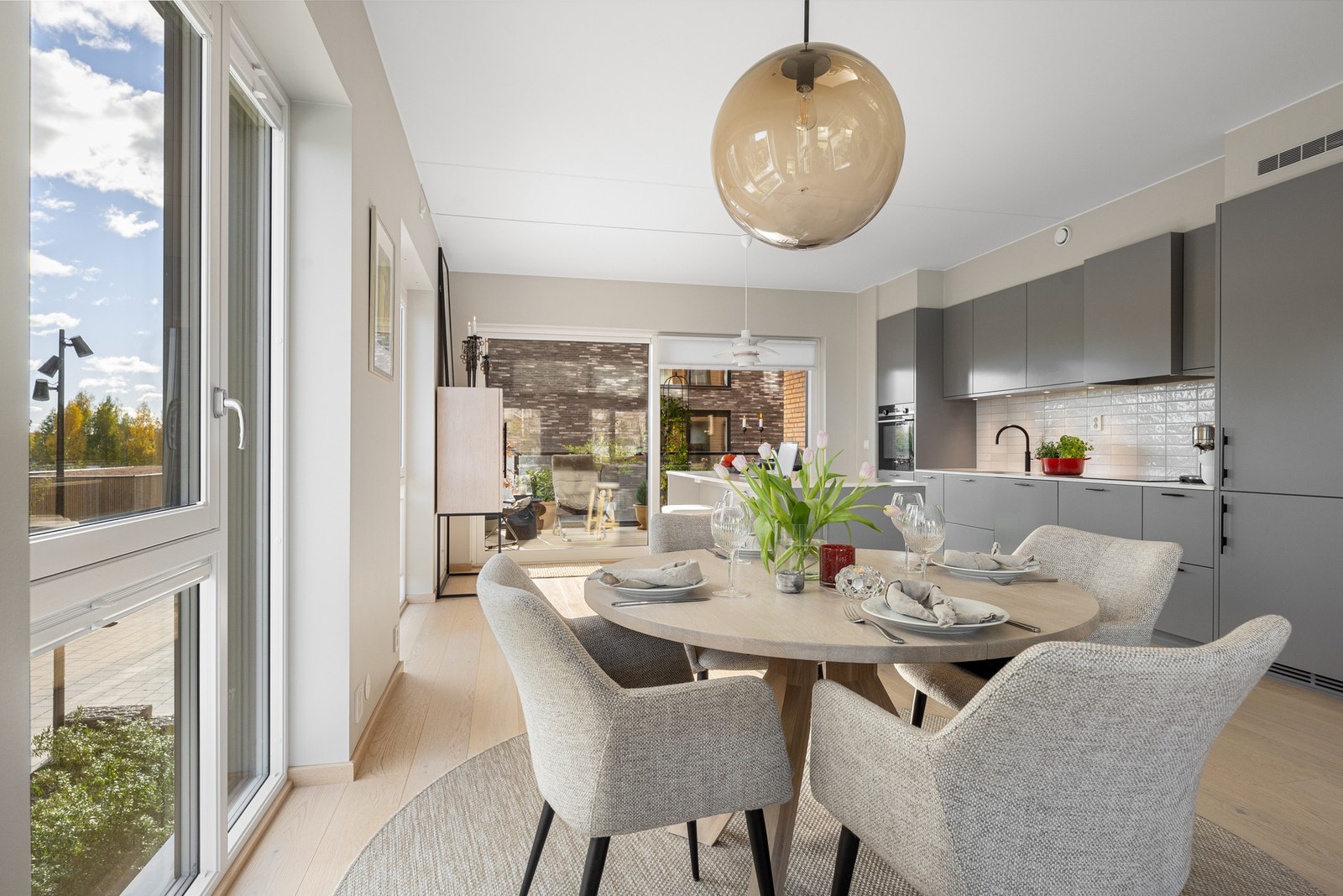 Oppholdsrom med stue og kjøkken i åpen løsning, samt plass til spisebord mellom sonene Galleribilde