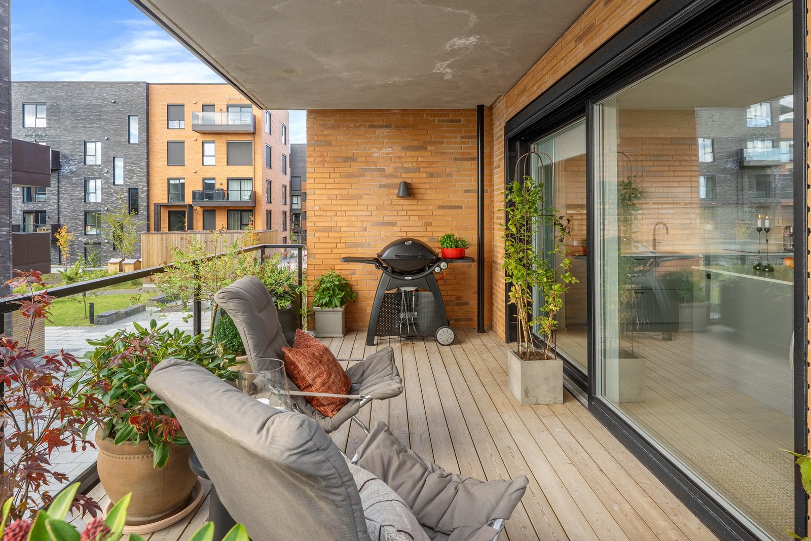 Store skyvedører mellom oppholdsrom og uteplass gir en sømløs overgang Galleribilde