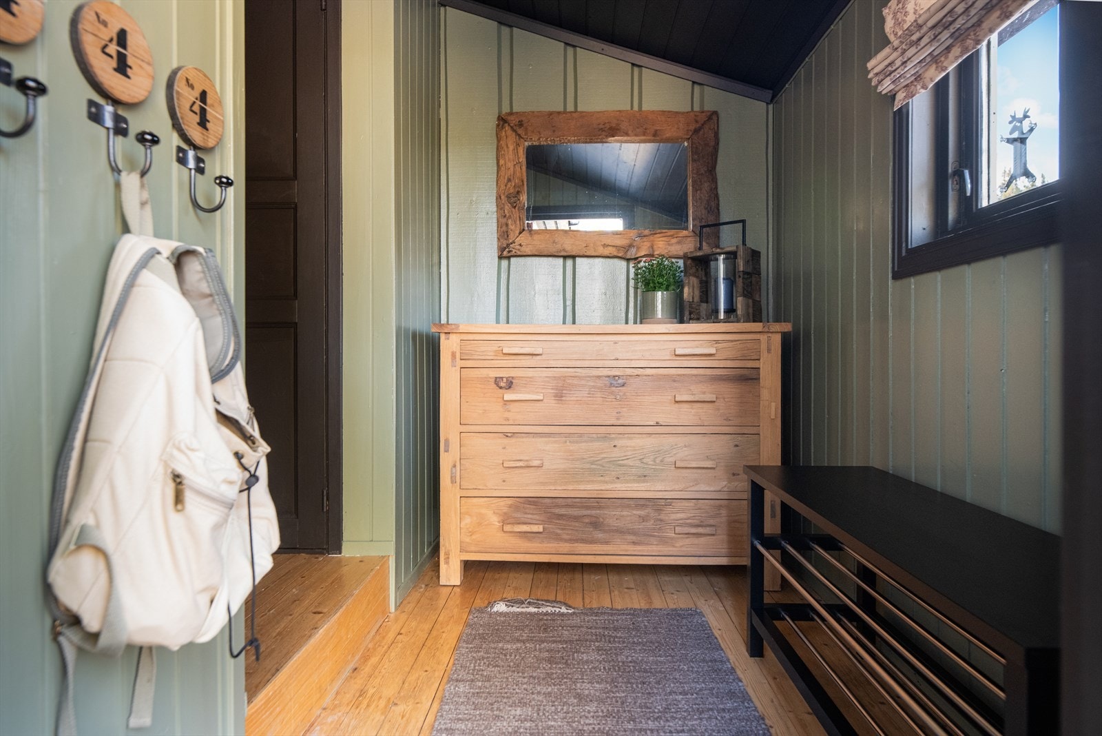 Pen entré med tregulv og malt panel på vegger. Her er det plass til sko og oppheng av yttertøy. Galleribilde
