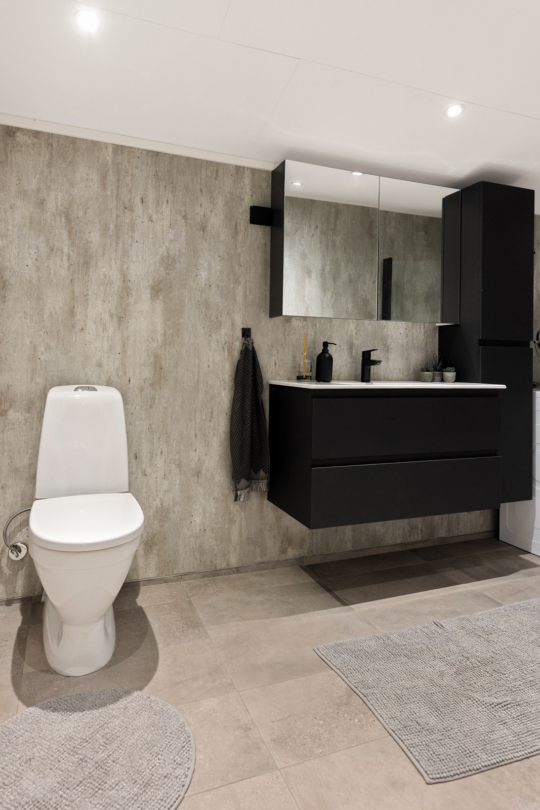 Badet ble modernisert i 2024 og har innredning i sort utførelse. Badet er utstyrt med WC, servant, dusjhjørne, opplegg for vaskemaskin og skapinnredning. Galleribilde