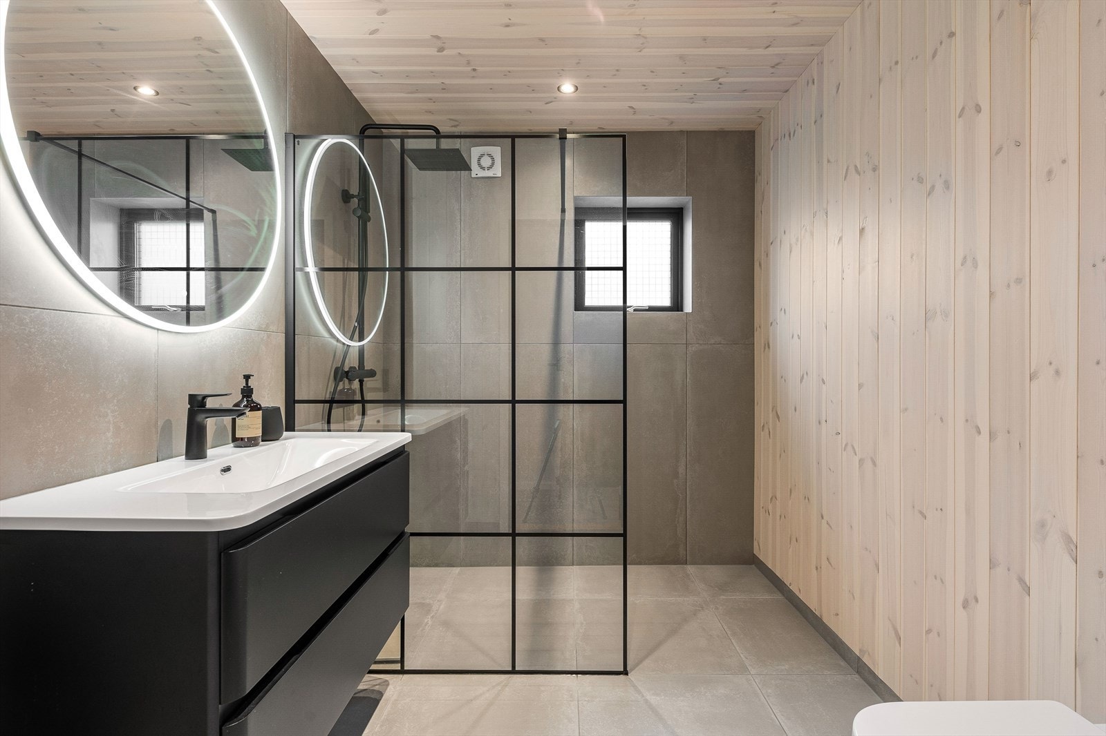 Det er to flotte bad med flis på gulv og flis/panel på vegger. Panel med downlights i himling Galleribilde