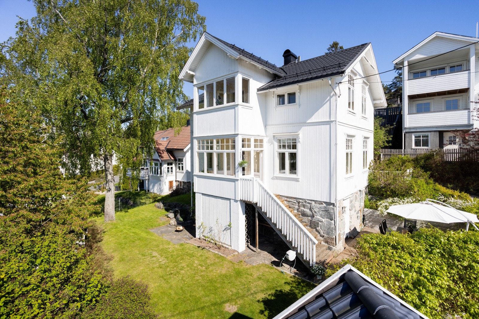 Grønn, frodig hage og markterrasse. Galleribilde
