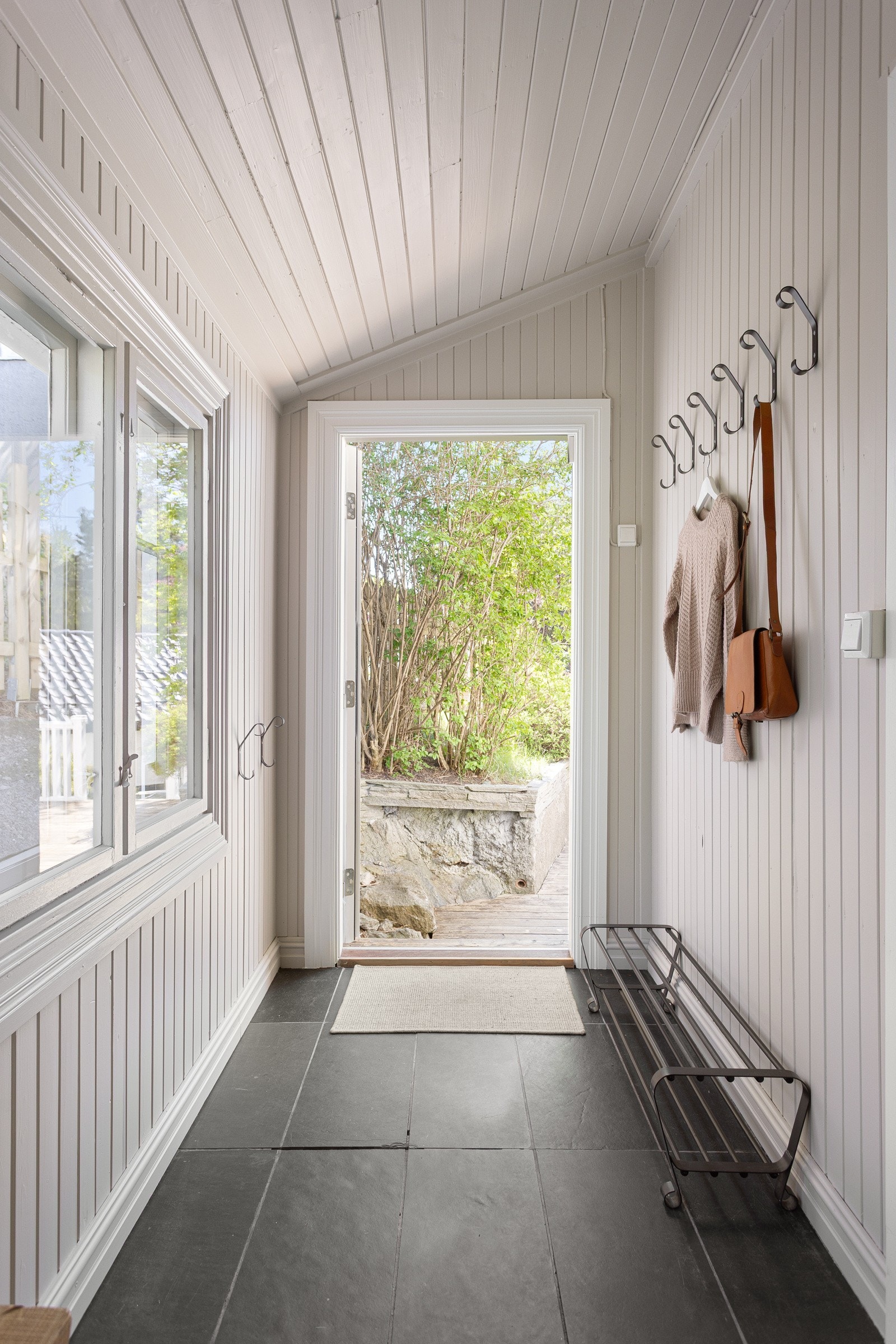 Inngangspartiet er flislagt, og tilpasset funksjonell bruk med plass til oppheng og oppbevaring Galleribilde