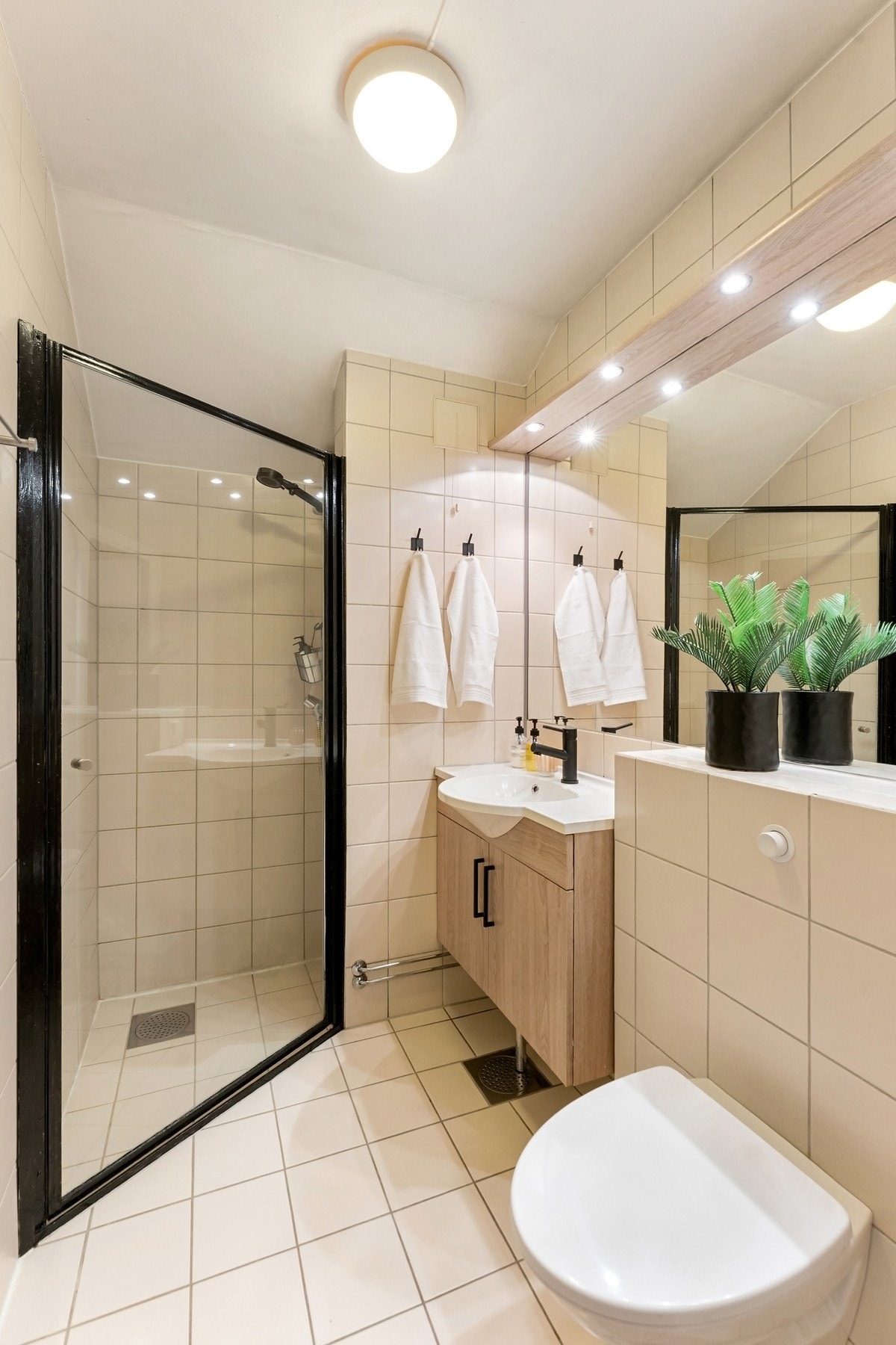 Delikat, flislagt baderom med dusjhjørne og elektriske varmekabler i gulvet. Galleribilde