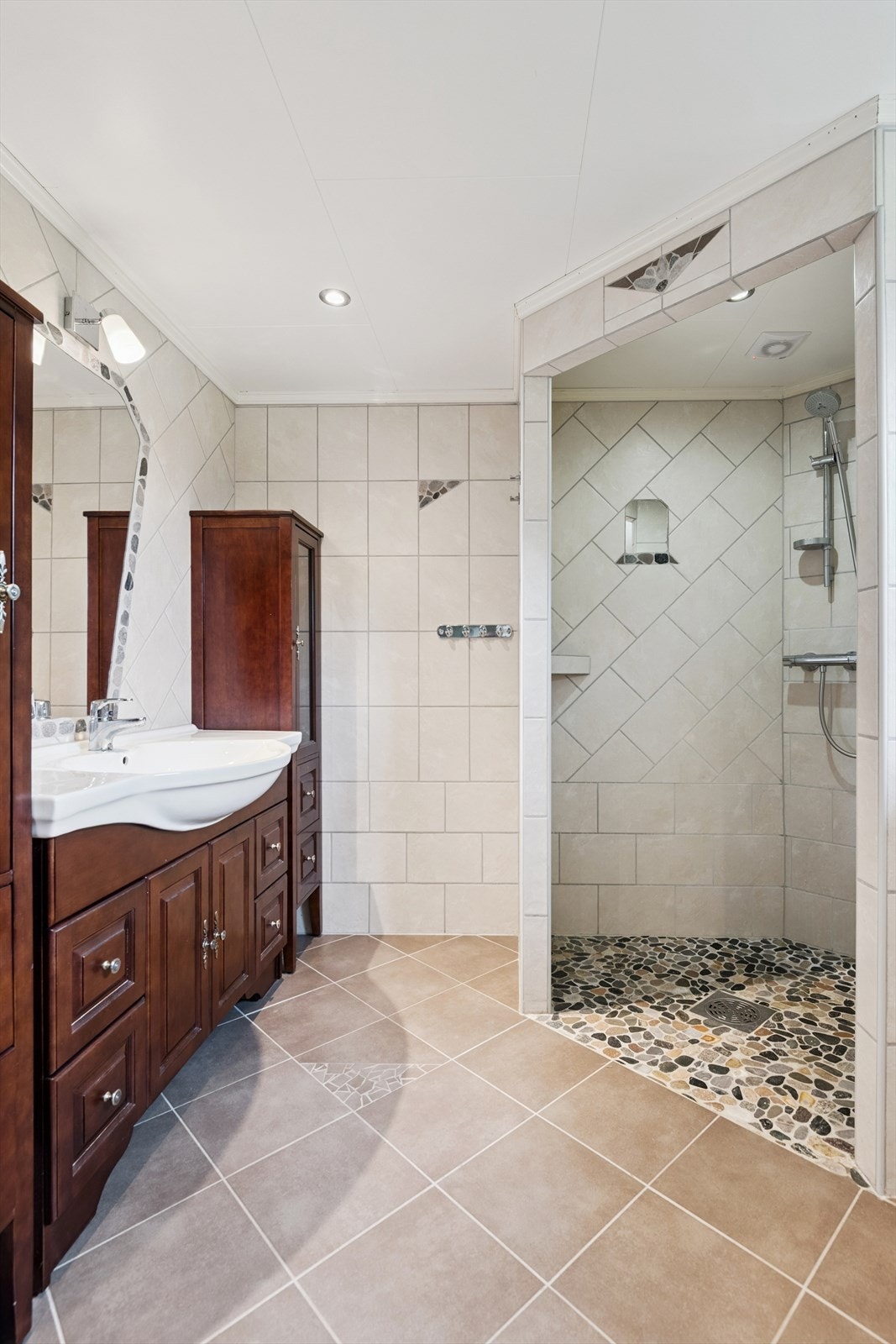 Hovedbadet fra 2014 i første etasje er flislagt og utstyrt med en romslig dusjnisje. Galleribilde