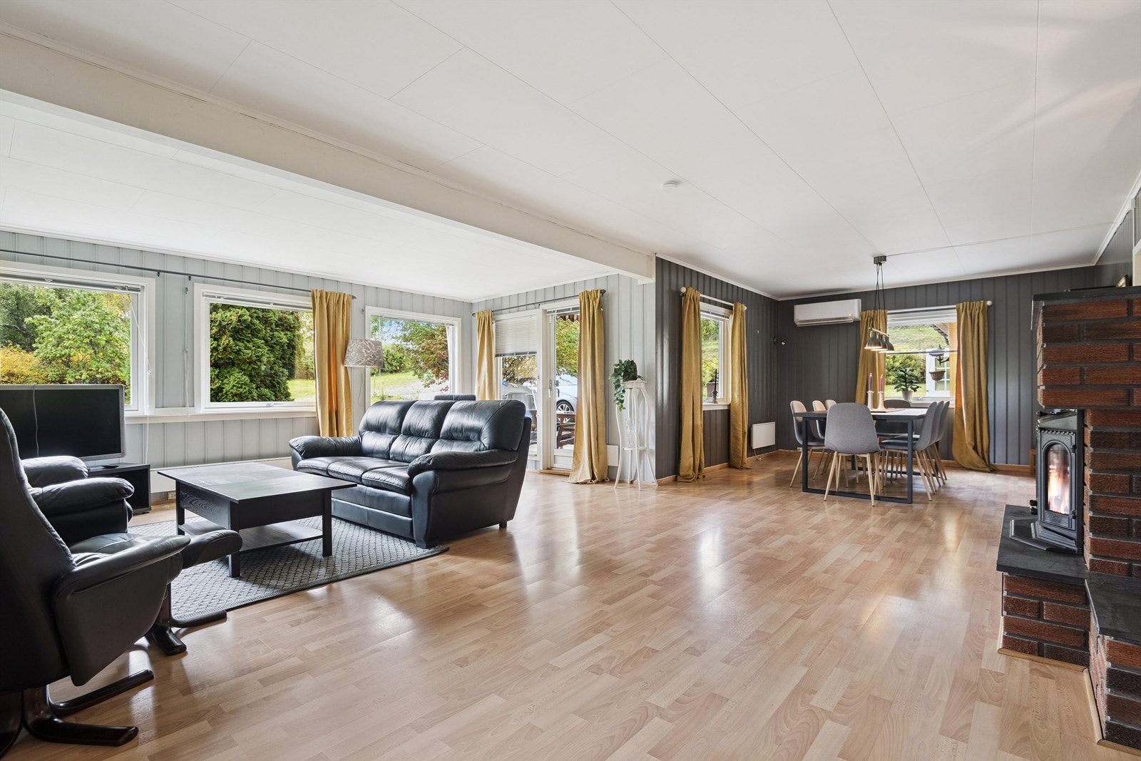 Stuen og spisestuen utgjør et stort, åpent oppholdsrom med laminat på gulvet. Galleribilde