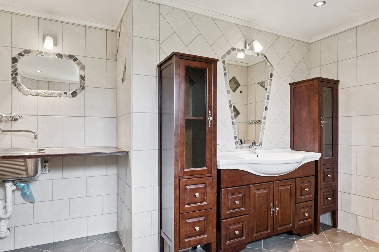 Baderomsinnredningen har gode oppbevaringsmuligheter og en praktisk utslagsvask og opplegg for vaskemaskin. Galleribilde