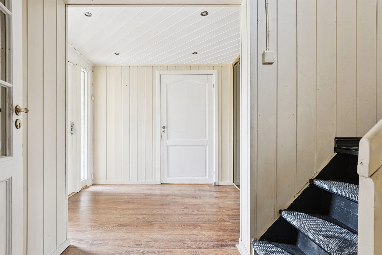 Fra gangen fører en malt tretrapp videre opp til boligens andre etasje. Galleribilde