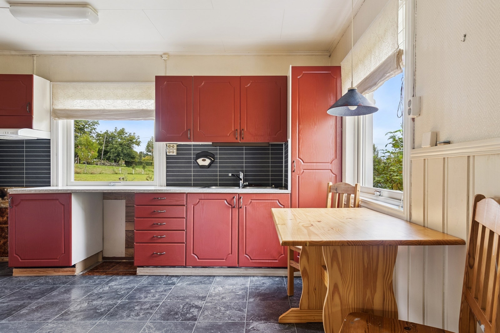 Kjøkkenet har en eldre innredning med plass til en liten spiseplass ved vinduet. Galleribilde