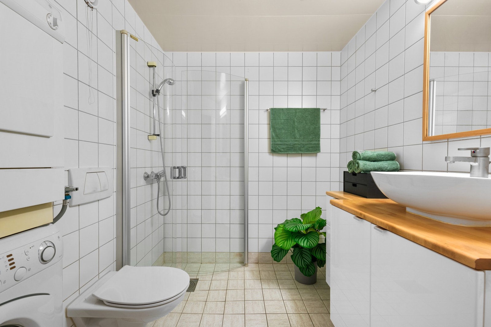 Badet fremstår som pent med nøytrale fliser på gulv og vegg samt gulvvarme. Galleribilde