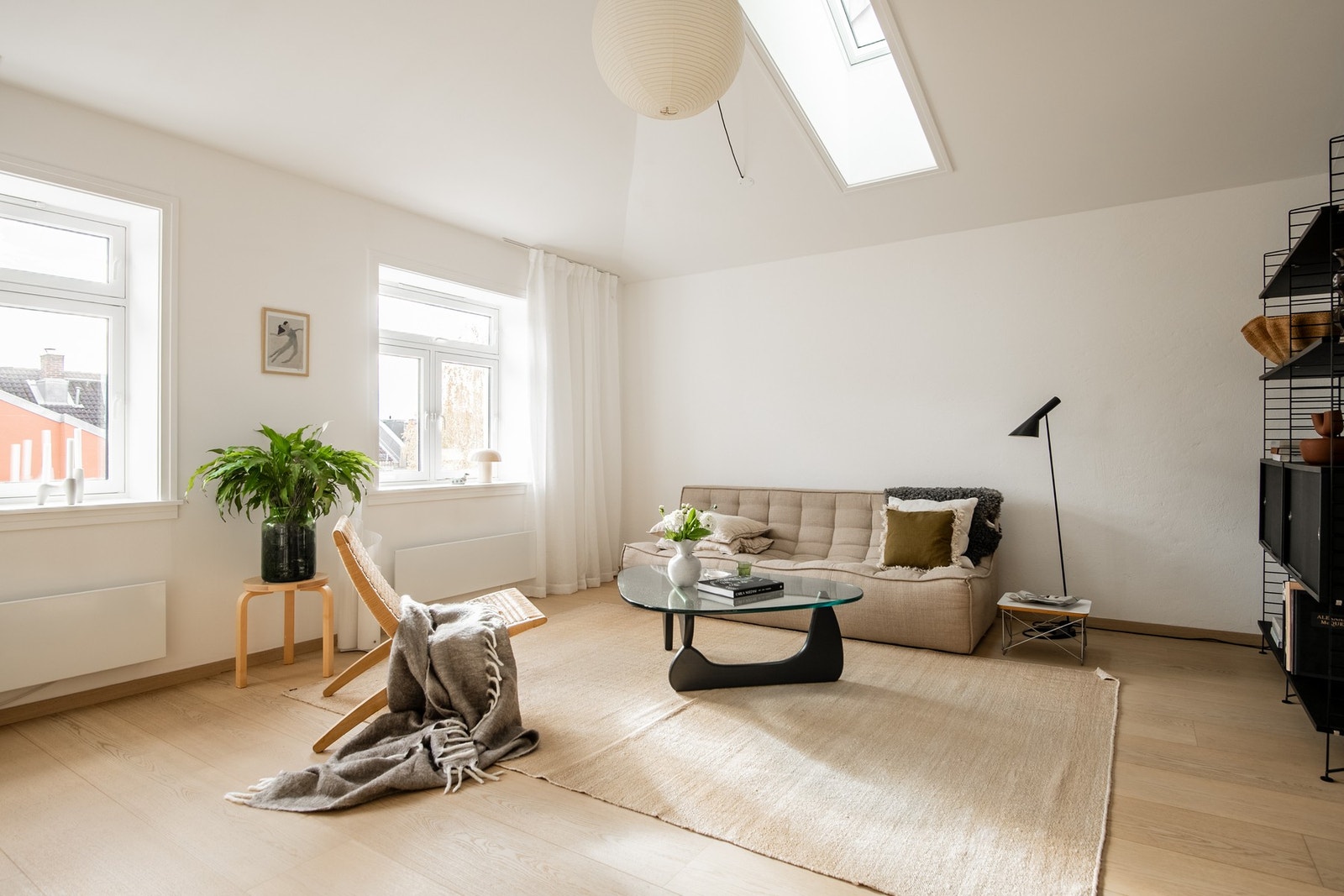 Rommet har en luftig atmosfære med god takhøyde og lys fra flere retninger, noe som bidrar til en følelse av å bo i et lite hus midt i byen. Galleribilde