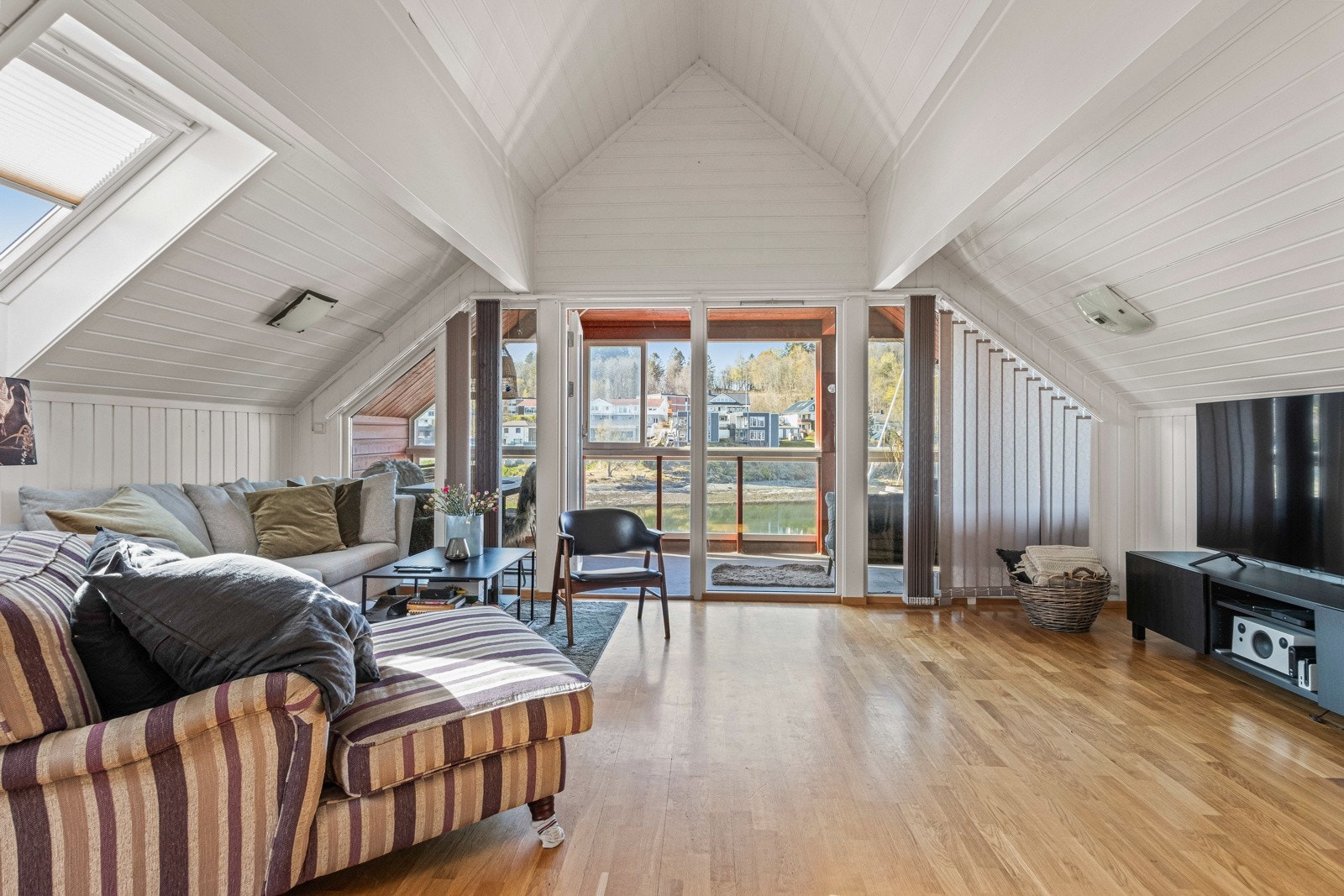 Romslig stue med plass til flere sittegrupper. Galleribilde