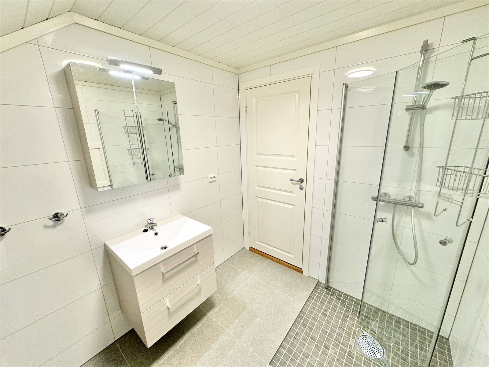 Badet i denne leiligheten er utstyrt med dusj m/glassvegger, vask, toalett og opplegg til vaskemaskin/tørketrommel. Galleribilde