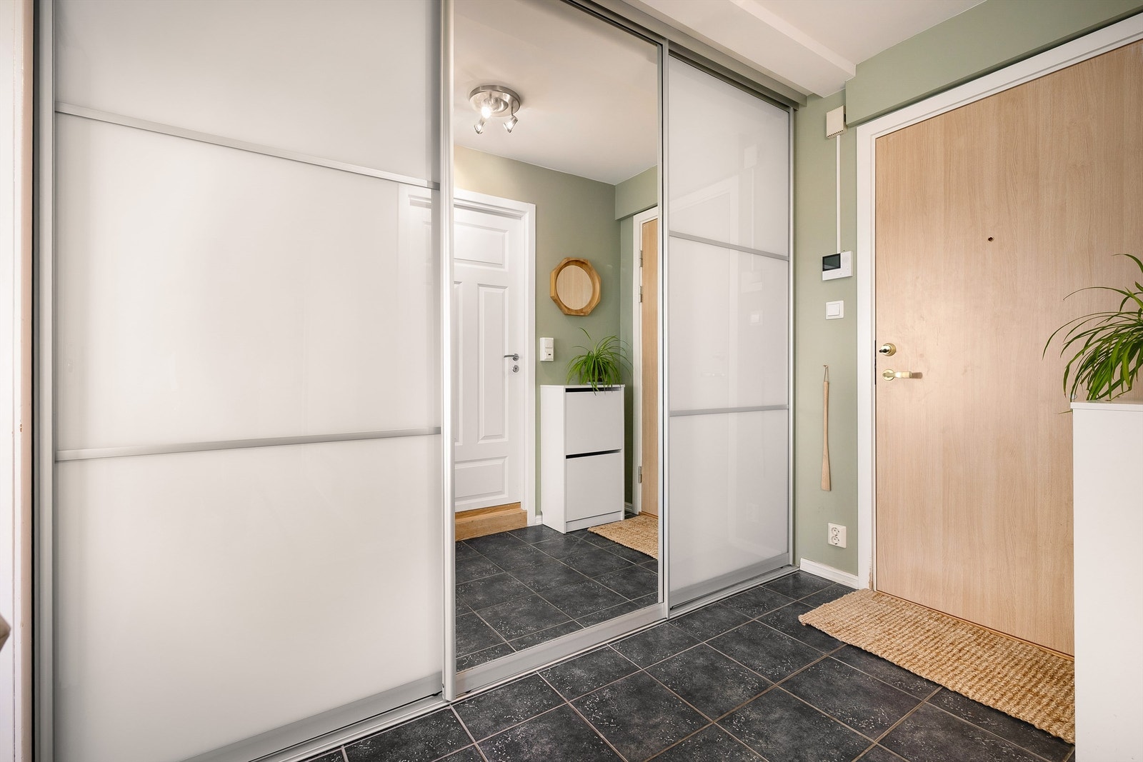 Velkommen inn! Entréen er lys og innbydende og gir et umiddelbart godt førsteinntrykk. Det er rikelig med oppbevaringsplass i en romslig skyvedørsgarderobe. Galleribilde