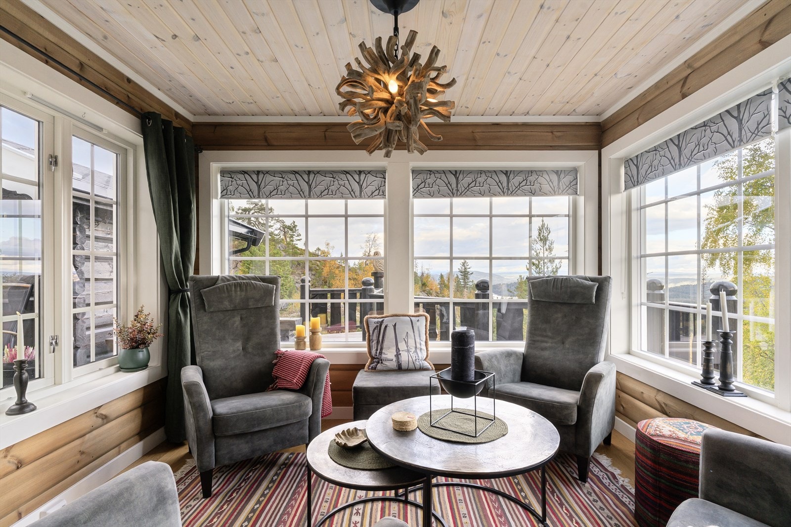 Stor og innbydende stue med bestående av to avdelinger. Denne delen man ser her har vinduer på tre yttervegger og gjør at man kan nyte den flotte utsikten rett fra godstolen. Galleribilde