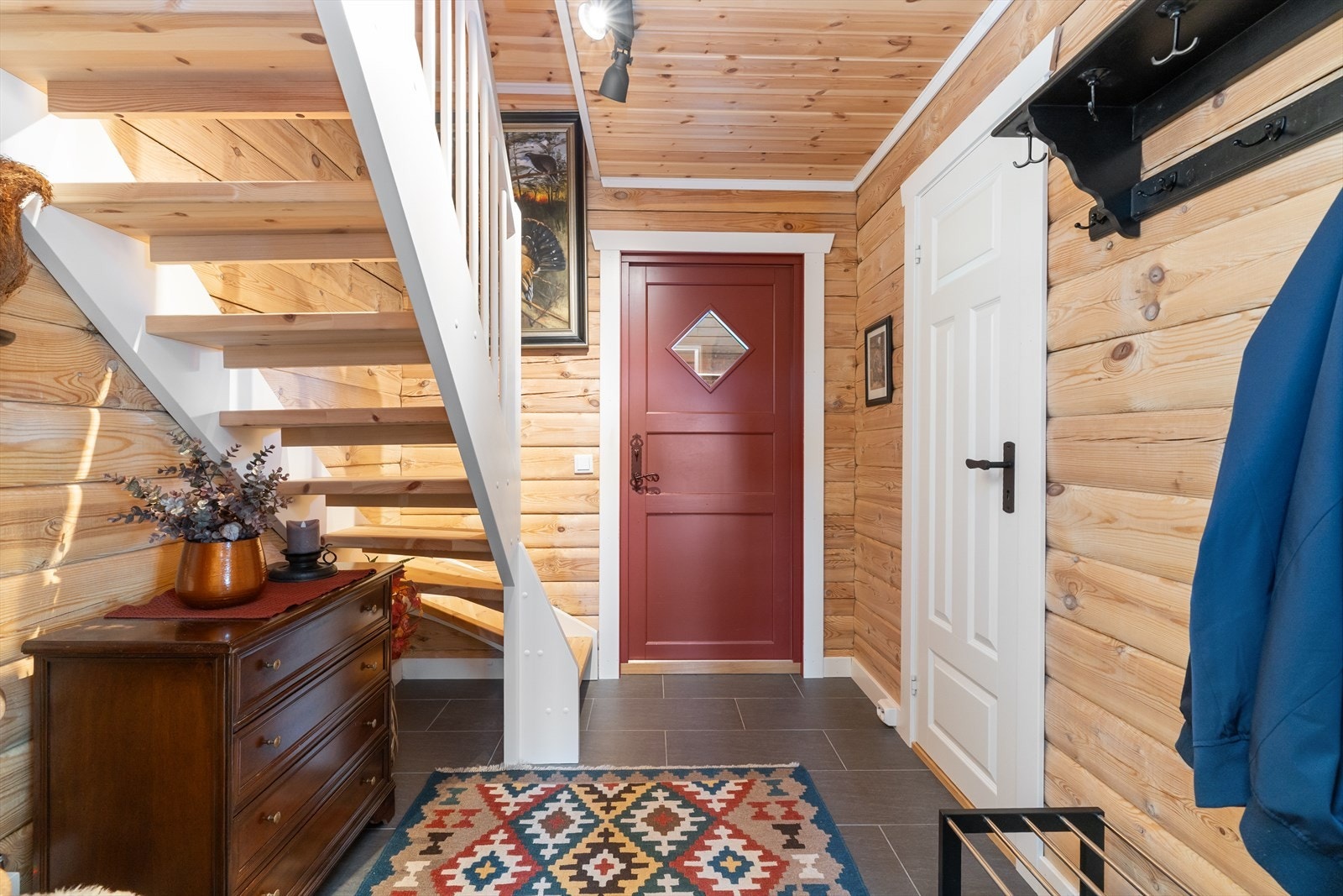 Hytta har en innbydende entré med flislagt gulv og varmekabler. Varmekablene er tilknyttet Sikom slik at man kan styre disse via telefonen hjemmefra. Galleribilde