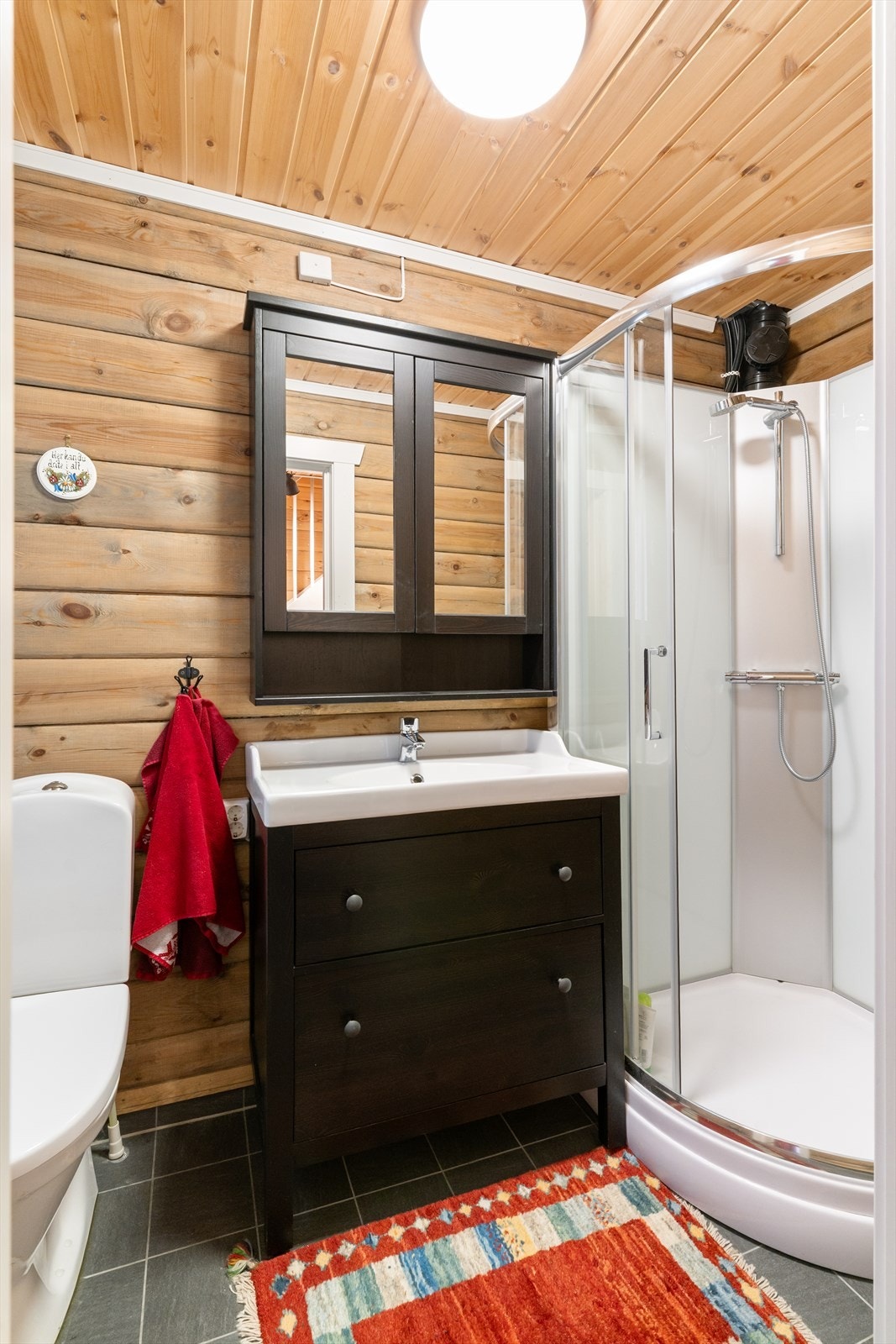 Badet har flislagt gulv med varmekabler og tømmervegger. Galleribilde