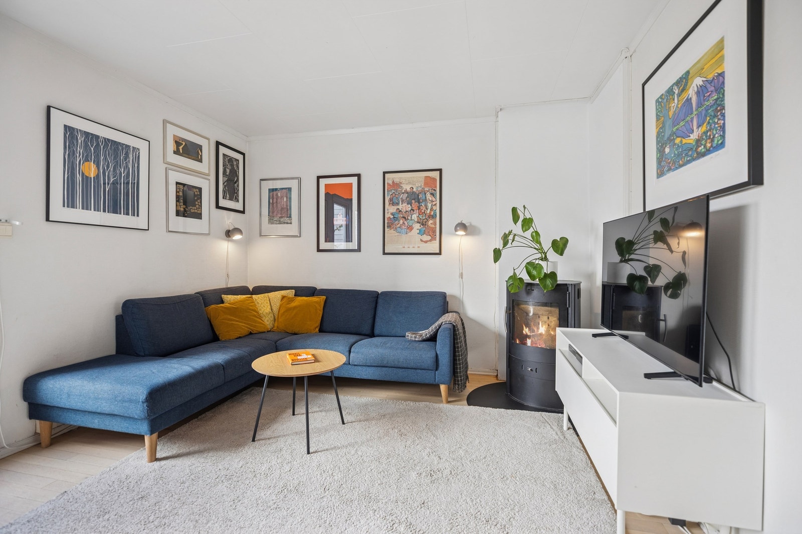 Stuen ligger lunt til i hjørnet av rommet, med god plass til sofakrok og TV. Peisen i hjørnet tilfører både varme og atmosfære. Galleribilde