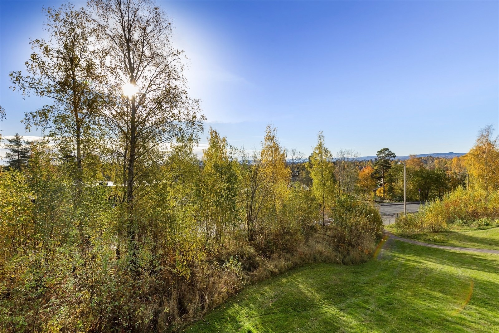 Fritt og hyggelig utsyn fra balkongen over plenarealer og nærområdet. Galleribilde