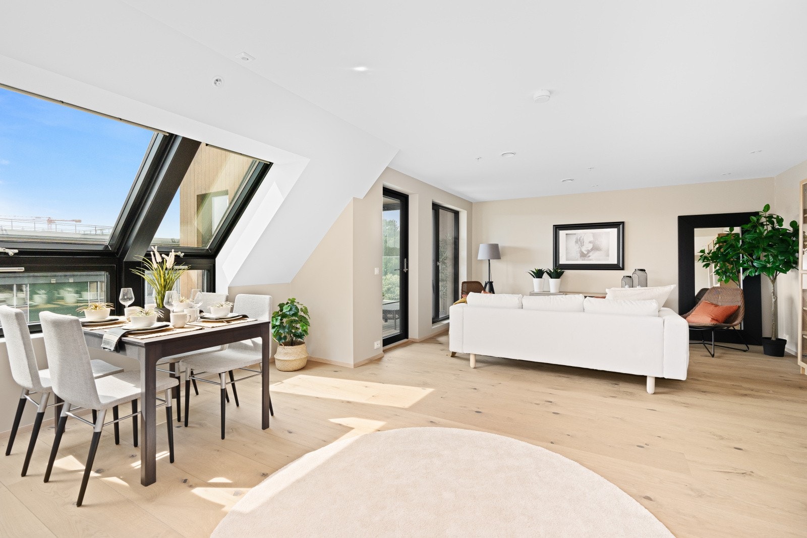 Stue med åpen løsning til kjøkken og utgang til innglasset balkong. Galleribilde