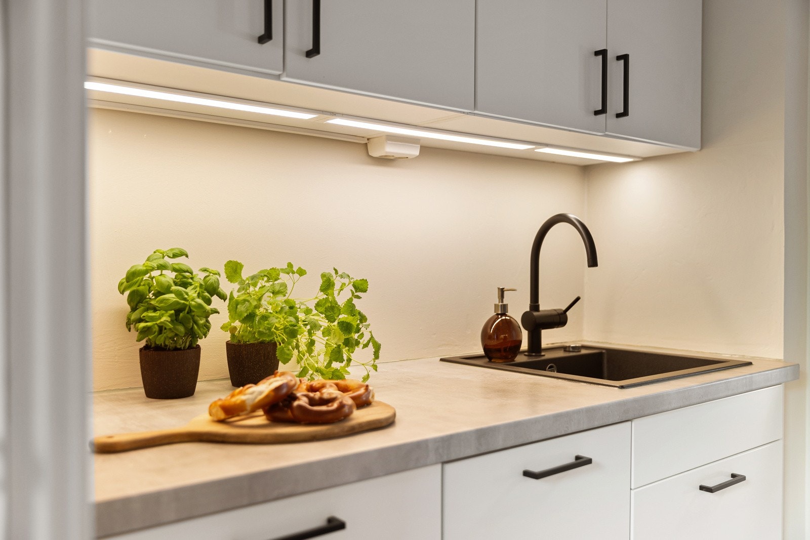 Stilren innredning med hvite glatte fronter og benkeplater i laminat. Galleribilde