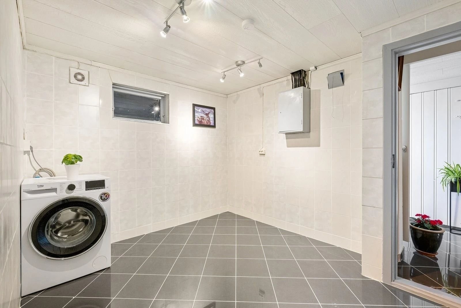 Romslig vaskerom med flislagt gulv og vegger, som gir både slitestyrke og enkel rengjøring. Rommet har opplegg for vaskemaskin og har god belysning. Galleribilde