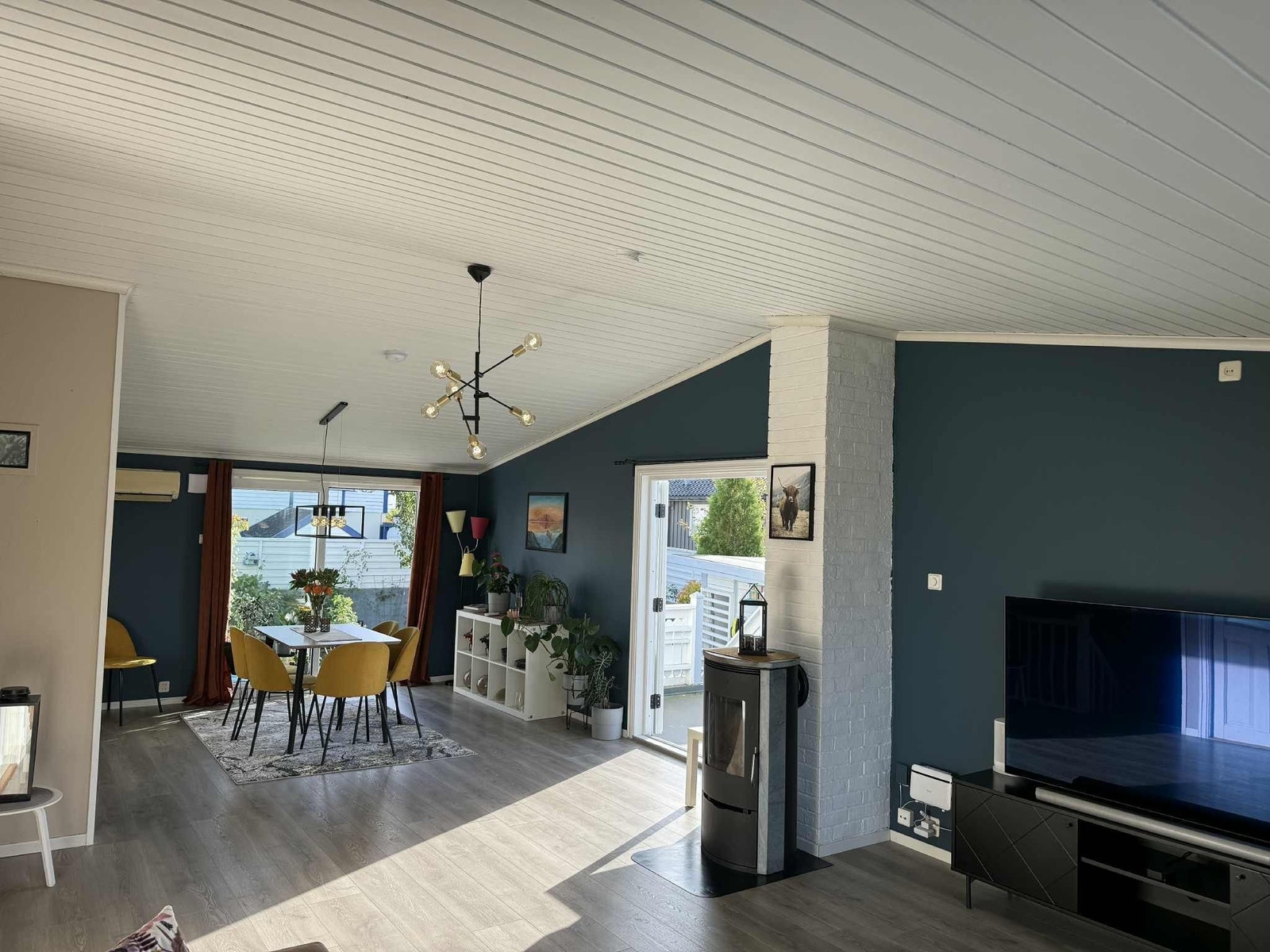 Romslig stue med vedovn, utgang til terrasse og store vindusflater som gir en luftig atmosfære. Galleribilde