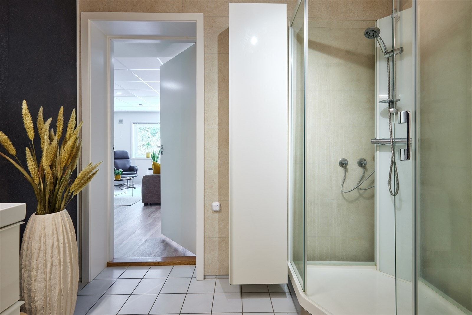 Kombinert bad-/vaskerom med baderomsplater på veggar og måla himling. Foto er styla. Galleribilde