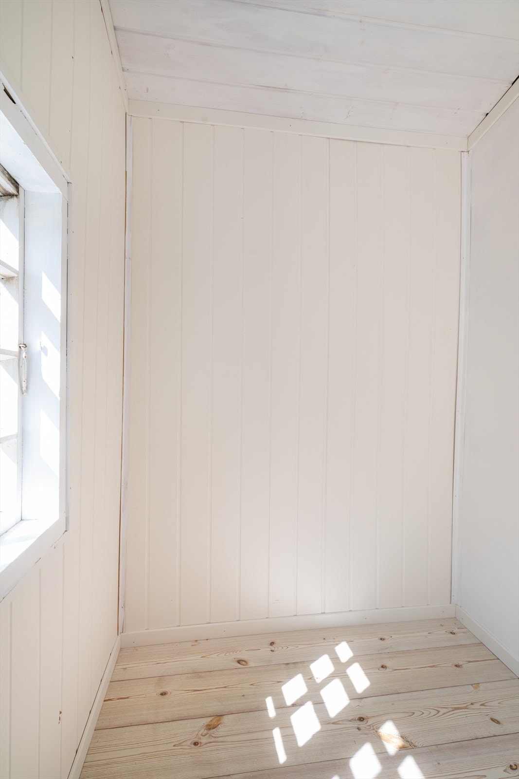 Her er det laminat på gulv og hvitmalte panelplater på vegger. Galleribilde