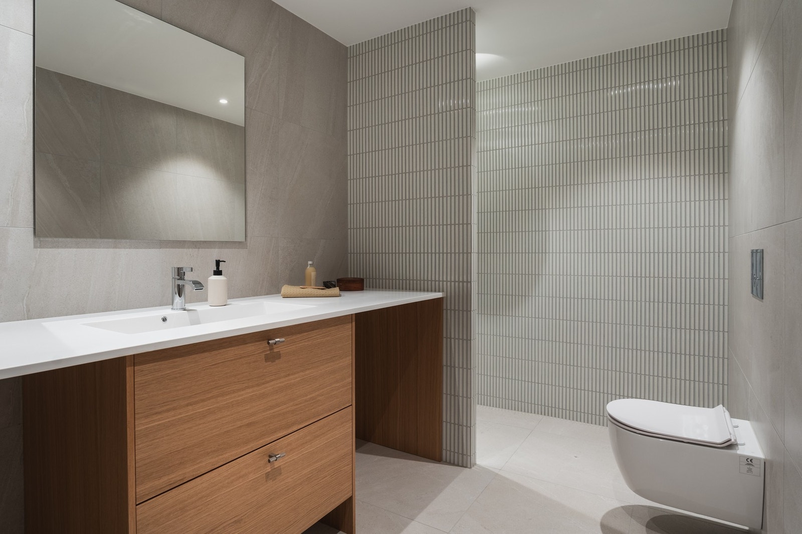 Smakfullt innredet baderom med lekre fliser og innredning med eikeskuffer. Galleribilde