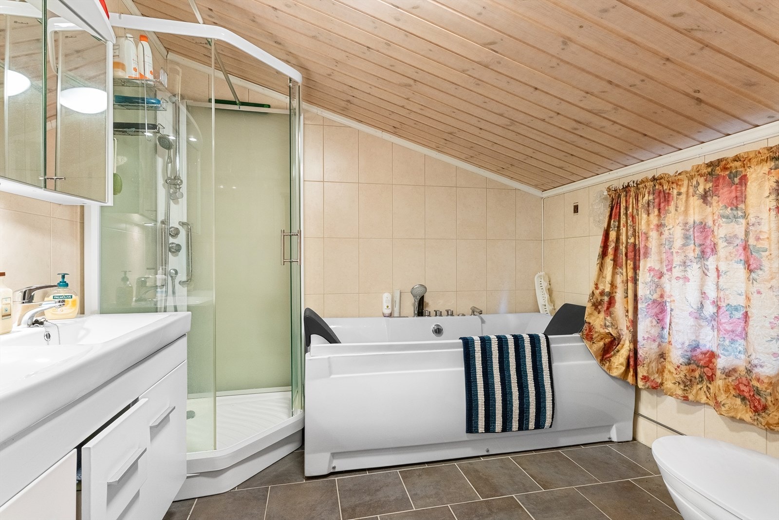 Badet er av ukjent alder. Udokumentert utførelse. Flislagt bad med innredning med 2 nedfelte servanter, toalett, dusjkabinett og badekar. Det er elektrisk styrt vifte. Galleribilde