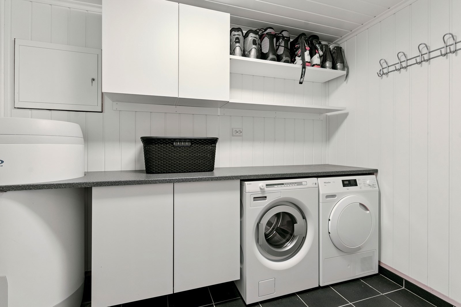 Vaskerom rett ved entré. Her er det også varmekablar på flislagt golv. På vegar er det lyst panel. Galleribilde