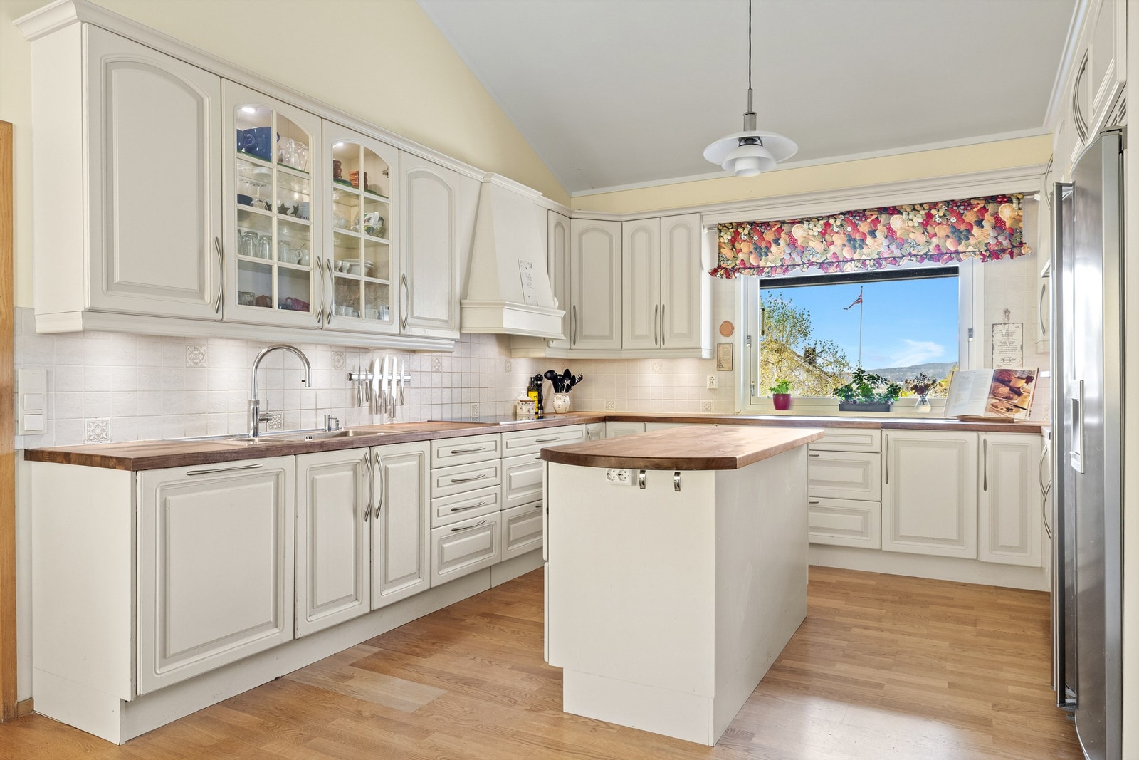 På kjøkkenet er det en praktisk kjøkkenøy som gir ekstra arbeidsflate og gjør matlagingen mer effektiv Galleribilde