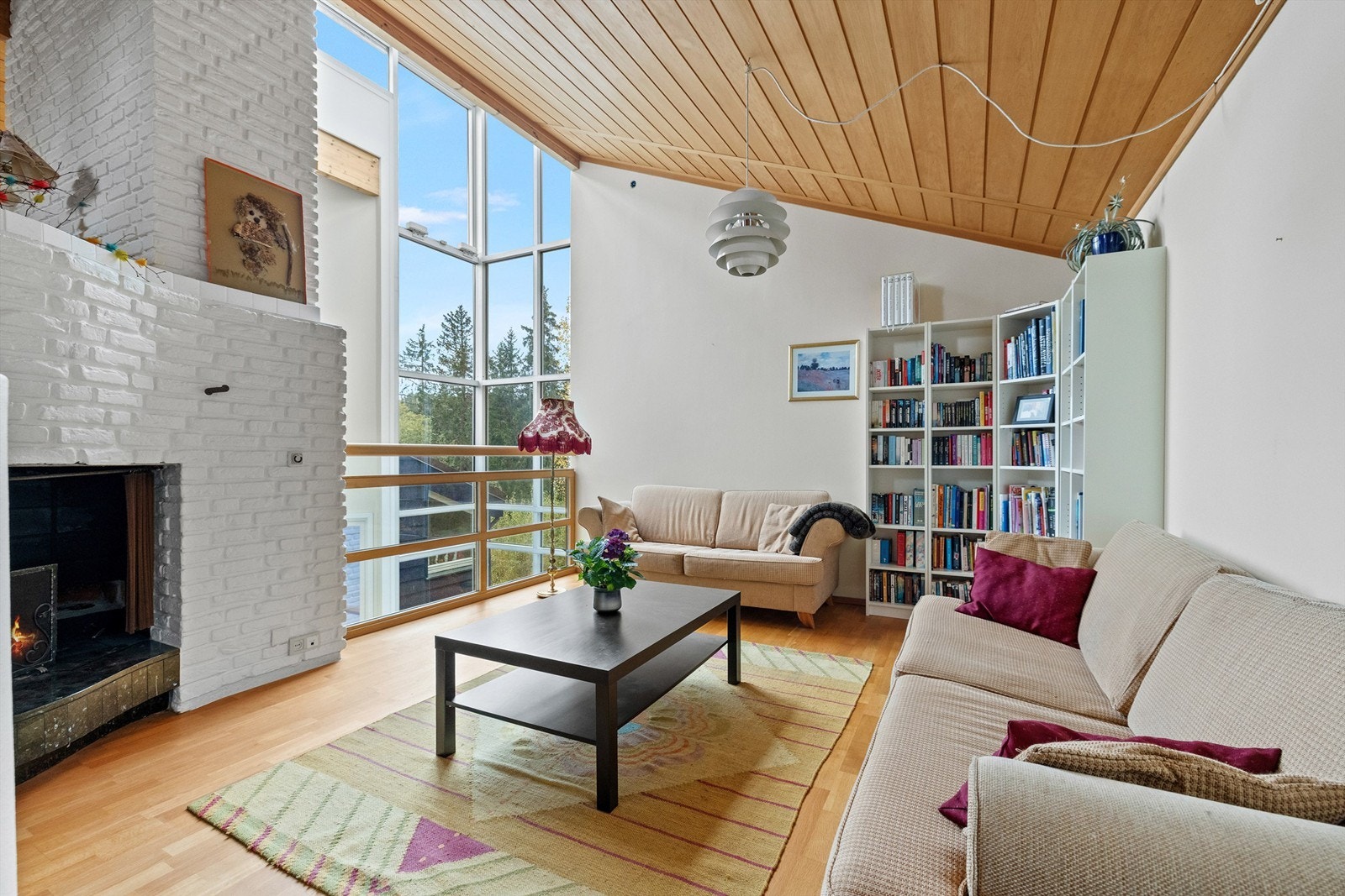 Med ekstra takhøyde og spektakulært lysinnslipp fra takvinduene fremstår oppholdsrommet som både luftig og elegant. Peisen setter prikken over i-en og gir rommet en varm, innbydende atmosfære Galleribilde