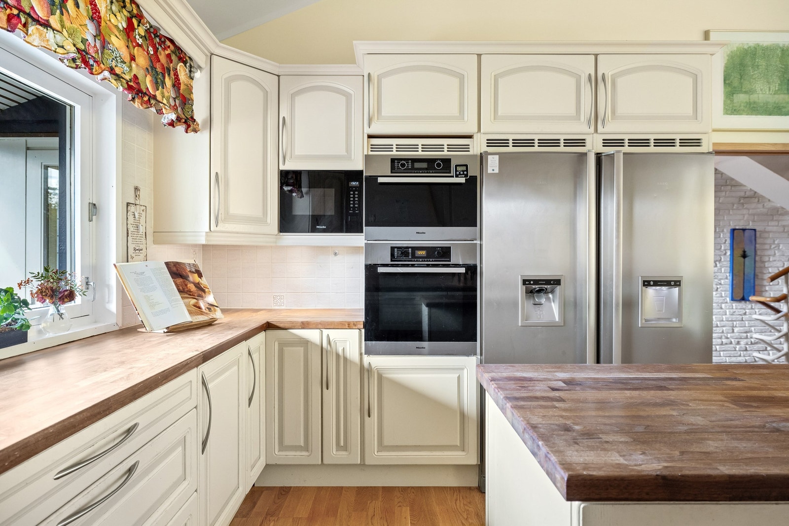 Kjøkkenet er utstyrt med integrerte hvitevarer som koketopp, stekeovn, dampovn og mikro plassert i høyskap, samt kaffemaskin og oppvaskmaskin Galleribilde