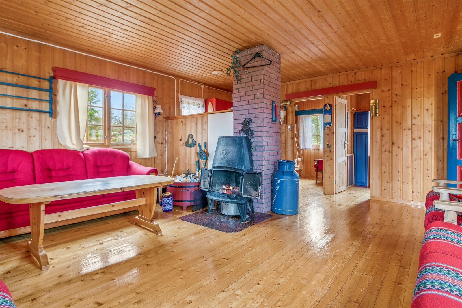 En sentralt plassert vedovn med steinforblending sørger for oppvarming og en lun atmosfære. Galleribilde