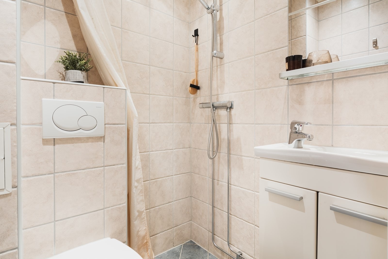 Badet er utstyrt med servant, servantskap, veggmontert wc, dusjhjørne og stoppekran. Galleribilde
