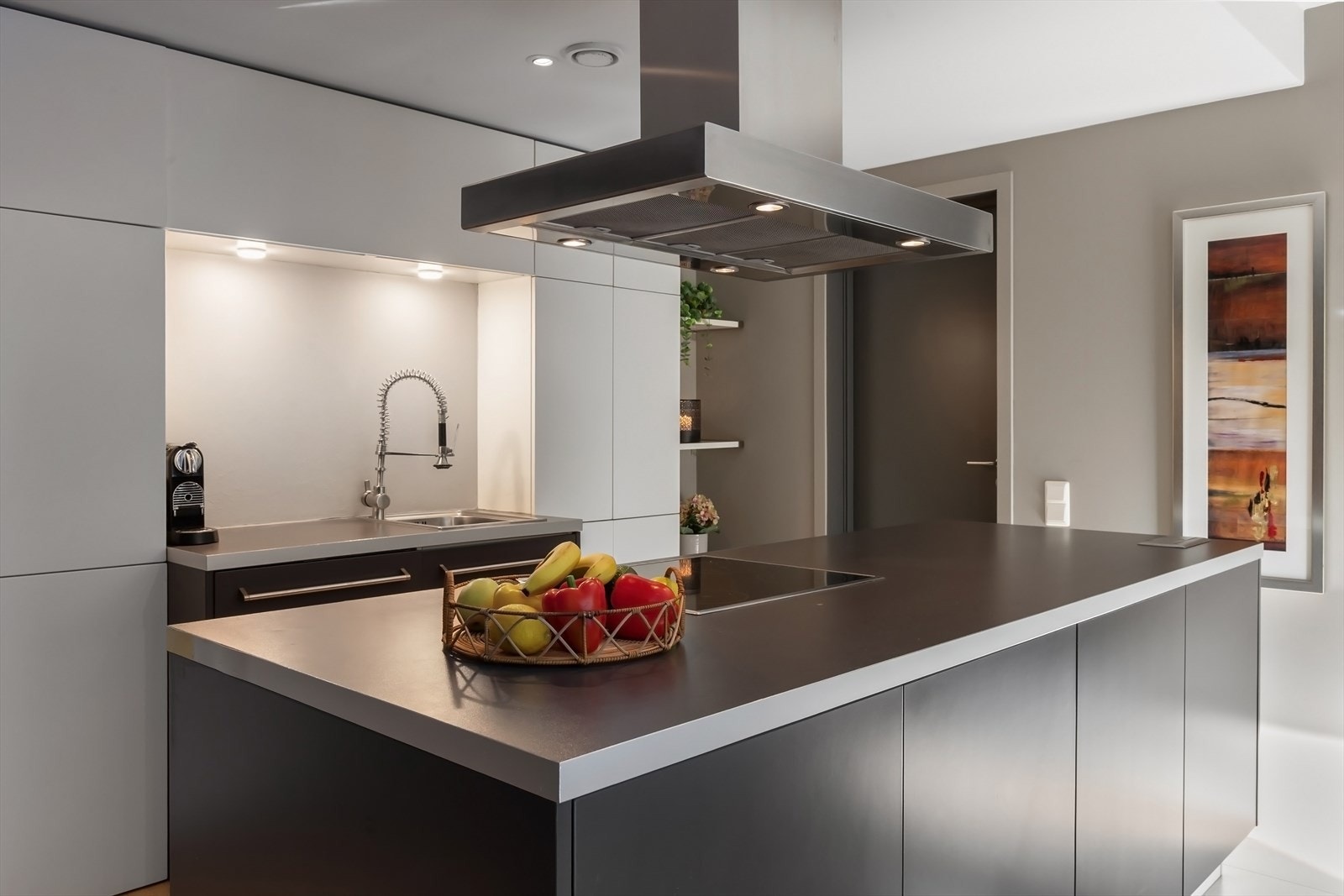 Eksklusiv kjøkkeninnredning fra Poliform Varenna med glatte fronter, laminat benkeplate og kjøkkenøy i tilsvarende utførelse Galleribilde