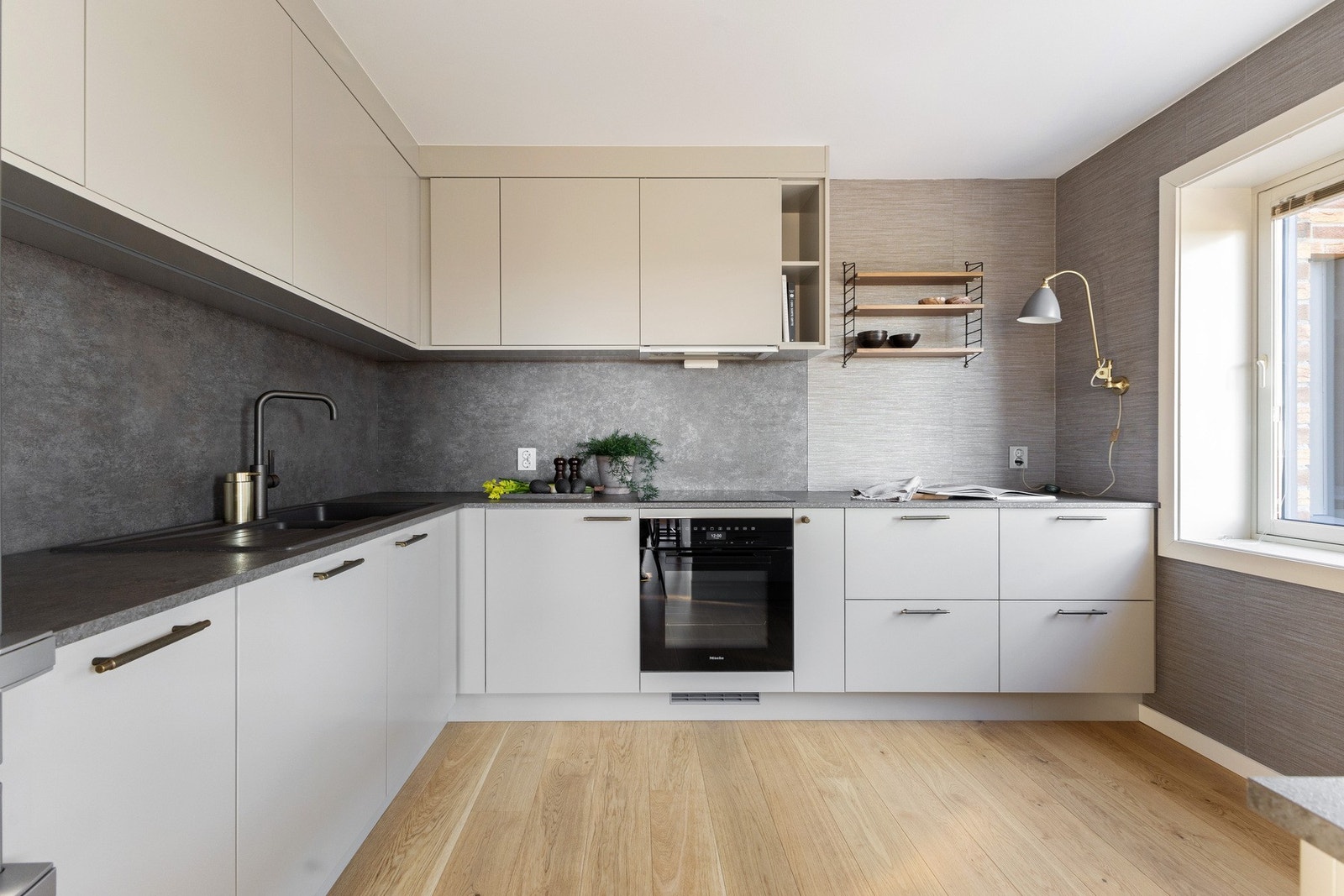 Stilren Strai kjøkkeninnredning fra 2022 med laminerte skrog, slette fronter og benkeplate i laminat med nedfelt oppvaskkum. Galleribilde