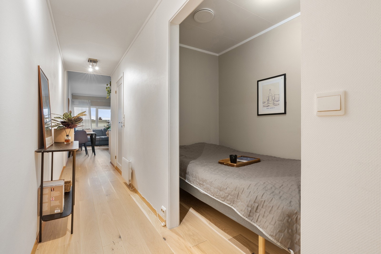 Sovealkove med plass til dobbeltseng og vegghengt oppbevaringsmøbel.
